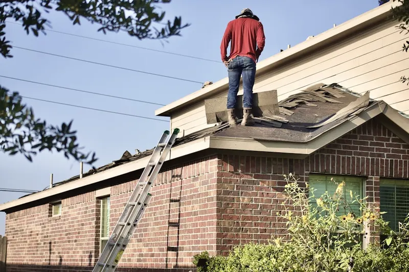Professional roofer working on a residential roof in Queensbury